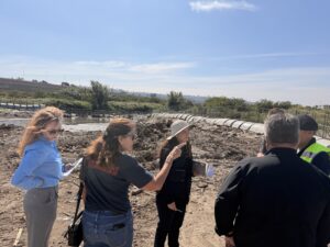 Group of people pointing and talking standing in front of the Tijuana River